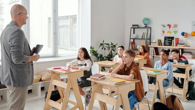 Ein Lehrer unterrichtet in einem Klassenraum Schülerinnen und Schüler