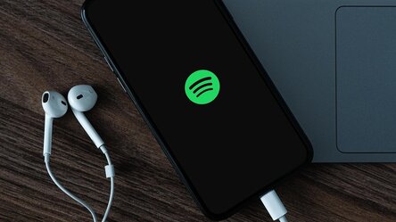 Mobiltelefon mit Kopfhörern (Symbolbild Podcast)