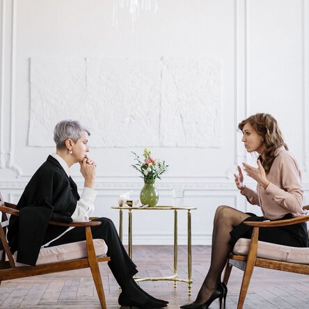 2 Frauen sitzen sich im Gespräch gegenüber
