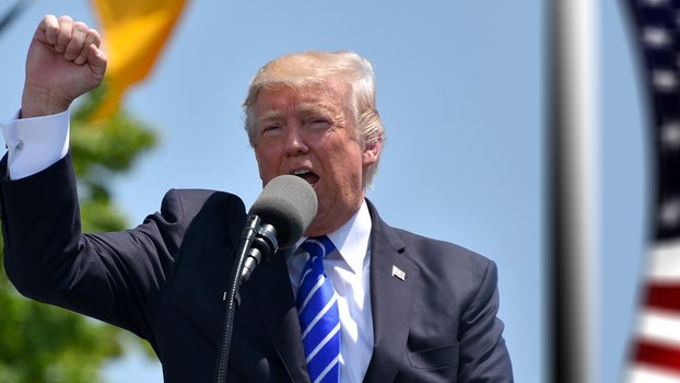 Donald Trump, US-Präsident (2017-2021) hält eine Rede im Freien, im Hintergrund die US-Flagge