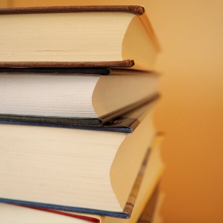 Bücherstapel auf orangenem Hintergrund