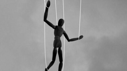 Marionette mit Hand des Marionettenspielers